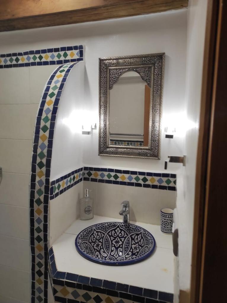 une salle de bain avec un lavabo et un miroir dans l'établissement Riad Averroès, à Fès