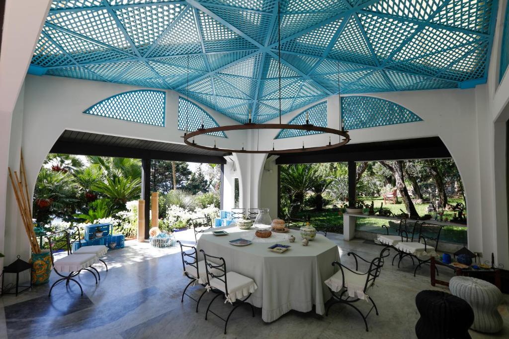 une salle à manger avec une table et un plafond bleu dans l'établissement Starhost - Villa il Poggio Amalfi Coast with pool, garden and terrace, à Vietri