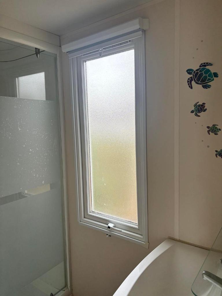 La salle de bains est pourvue d'une fenêtre et d'une baignoire. dans l'établissement MOBILE HOME 6 PERSONNES, à Port-la-Nouvelle 19 autres photos