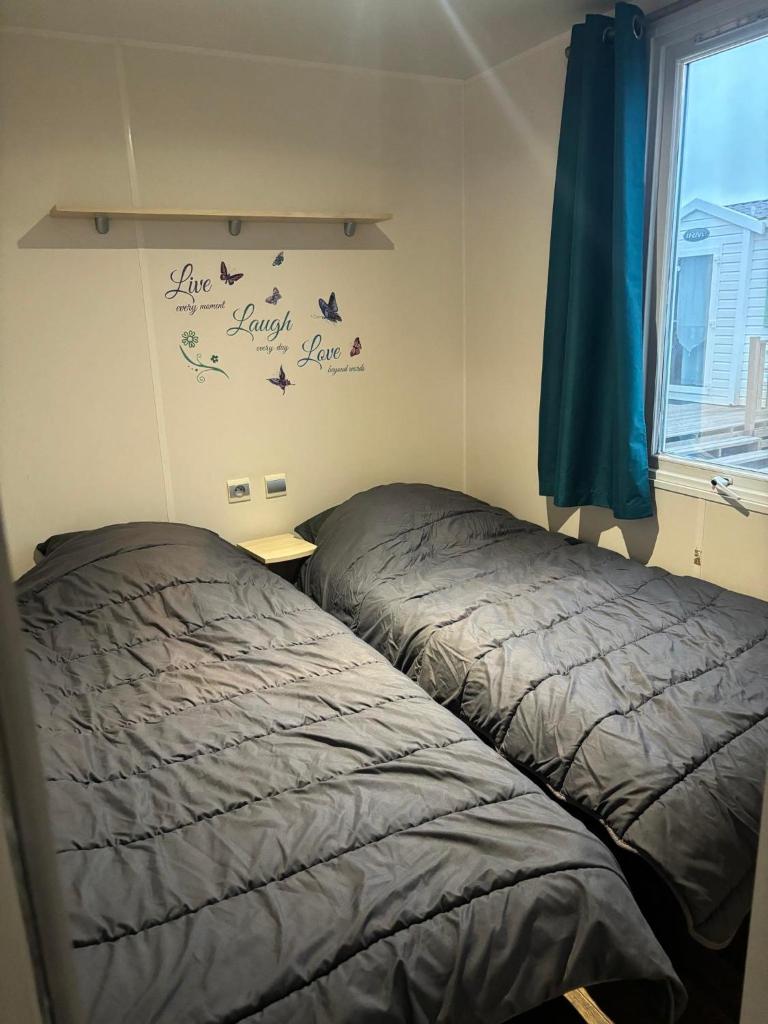 - une chambre avec deux lits à côté d'une fenêtre dans l'établissement MOBILE HOME 6 PERSONNES, à Port-la-Nouvelle