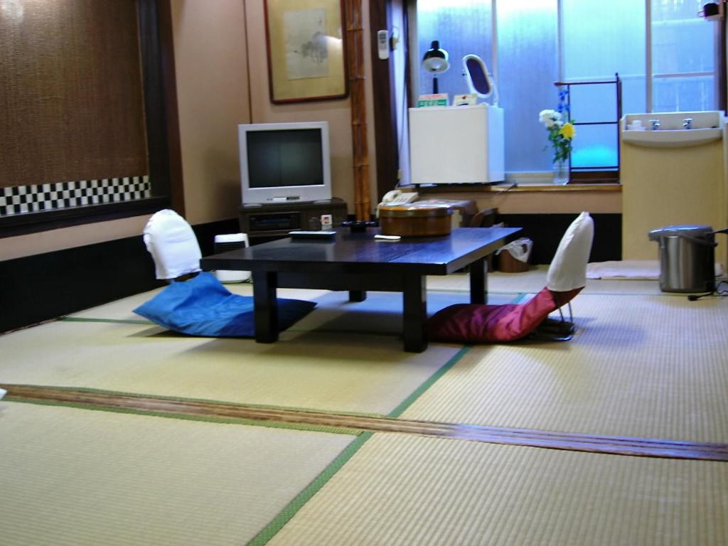 - un salon avec une table et un canapé-lit dans l'établissement Komecho Ryokan, à Imabari