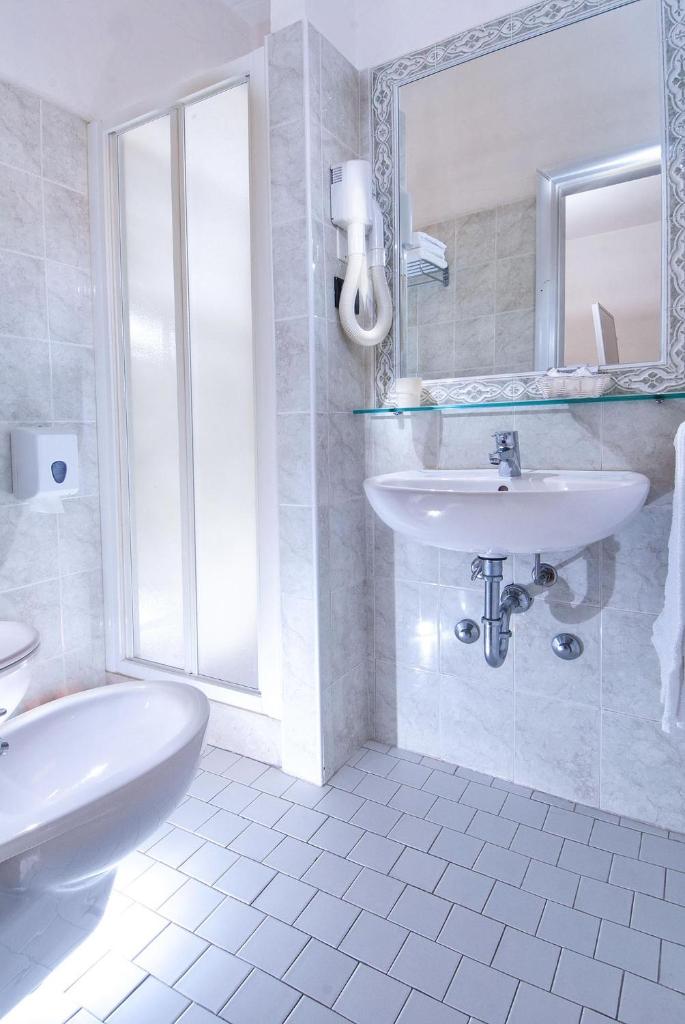 une salle de bain blanche avec un lavabo et un miroir dans l'établissement Hotel Stella Alpina, à Rimini 64 autres photos
