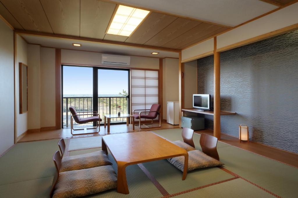 un salon avec une table et des chaises dans l'établissement Senri no Kaze, à Tateyama