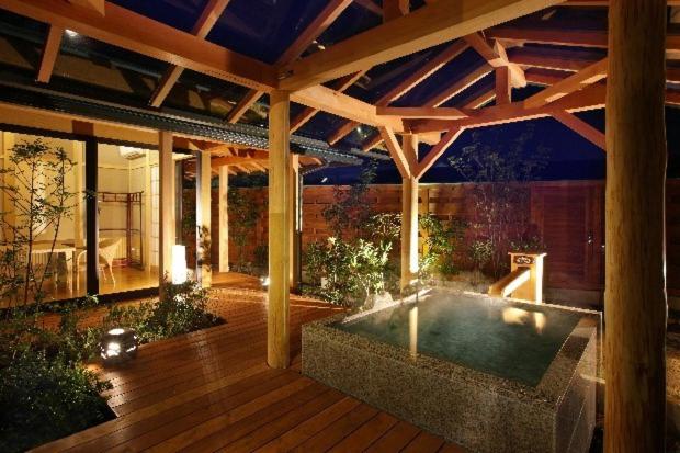 une terrasse en bois avec une piscine. dans l'établissement Hanashibuki, à Tateyama