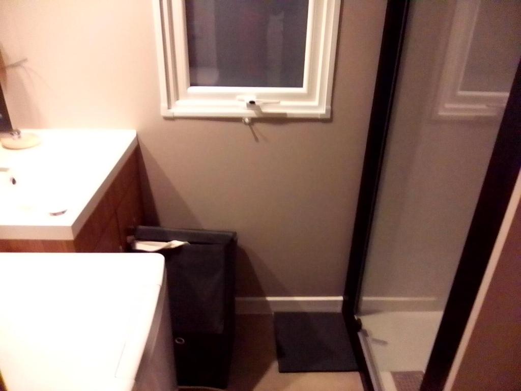 une salle de bain avec un lavabo et des toilettes et une fenêtre dans l'établissement FMLODGE-mobilhome jasmin, à Valras-Plage