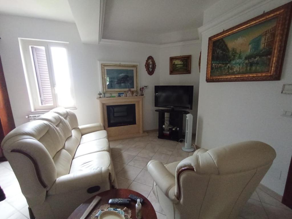 - un salon avec deux canapés blancs et une télévision dans l'établissement Villa Framaca, à Furnari