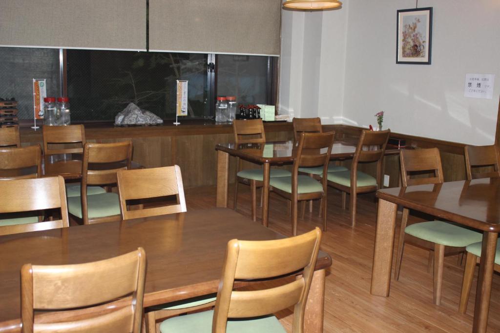 une salle à manger avec des tables et des chaises en bois dans l'établissement Ryokan Tanaka, à Takayama