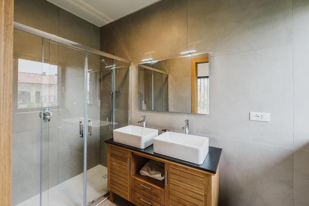 une salle de bain avec deux lavabos et une douche dans l'établissement Luxe Villa Maxime, à Lazise