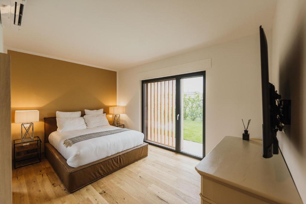 une chambre avec un lit et une grande fenêtre dans l'établissement Luxe Villa Maxime, à Lazise