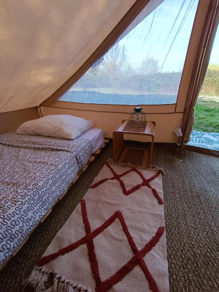 une chambre avec un lit et une grande fenêtre dans l'établissement Du cote de Roussay, à Roussay
