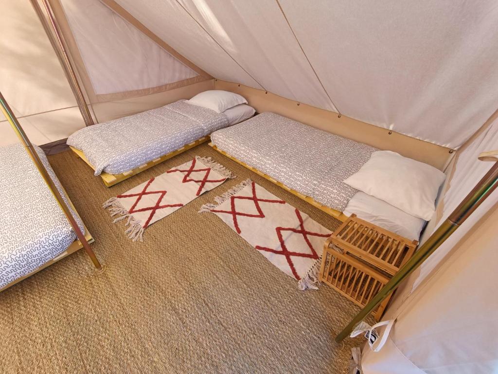 une chambre avec deux lits dans une tente dans l'établissement Du cote de Roussay, à Roussay