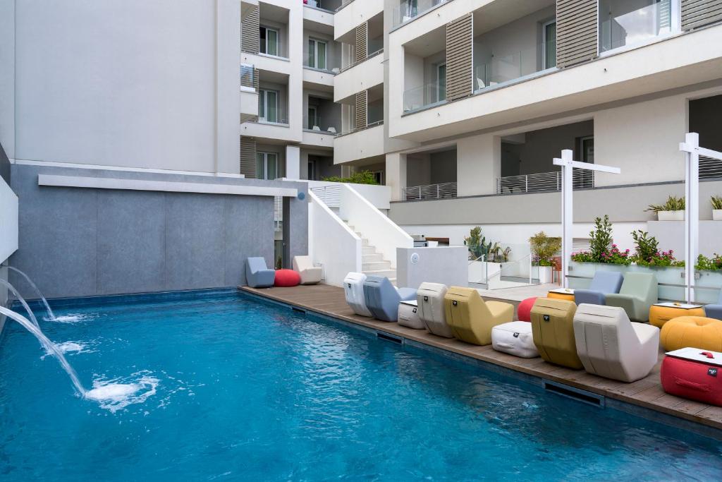 - une piscine avec des chaises et une fontaine dans l'établissement Albatros Beach Hotel, à Letojanni