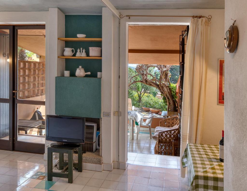 un salon avec une télévision et une salle à manger dans l'établissement Villino Mimma, à Campu Longu