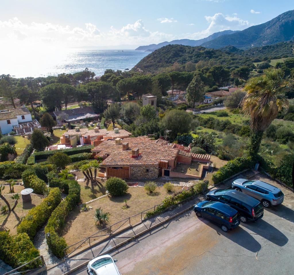 Deux voitures garées sur un parking en face d'une maison dans l'établissement Villino Mimma, à Campu Longu
