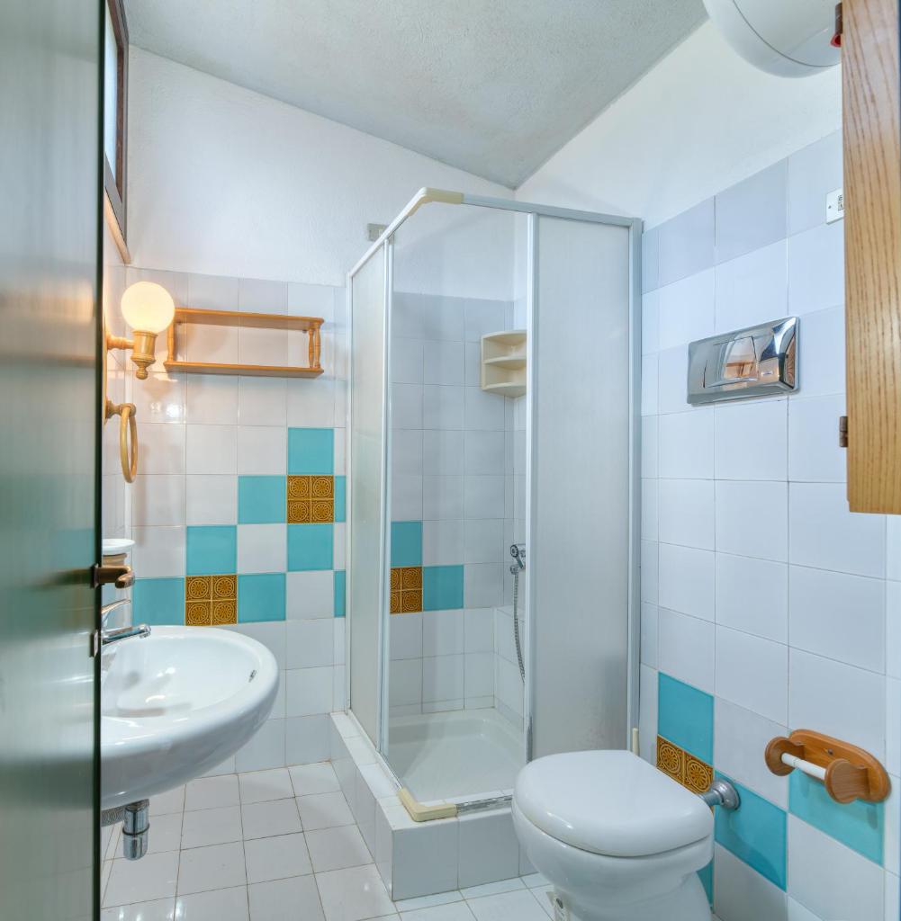 une salle de bain avec une douche, des toilettes et un lavabo dans l'établissement Villino Mimma, à Campu Longu