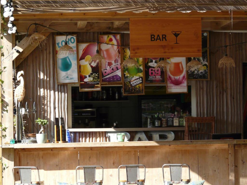 - un bar avec des chaises et des affiches sur le mur dans l'établissement Mobil-Home pour 6 personnes (3 chambres), à Narbonne