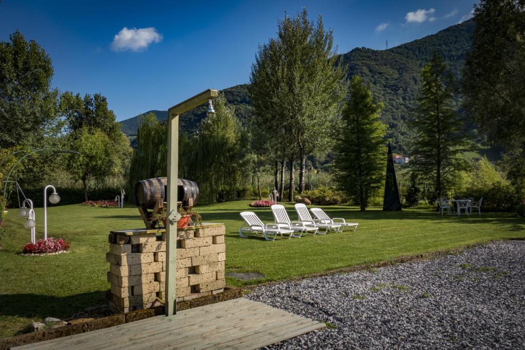 - un groupe de chaises longues dans un parc avec une fontaine dans l'établissement Albergo La Romanella, à Spinone Al Lago