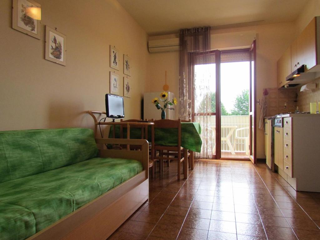 un salon avec un canapé vert et une table dans l'établissement Appartamenti Valbella, à Bibione