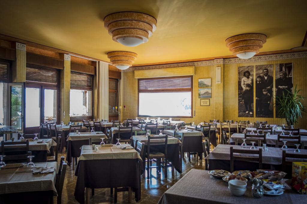 un restaurant avec des tables et des chaises et un grand écran dans l'établissement Albergo La Romanella, à Spinone Al Lago 28 autres photos