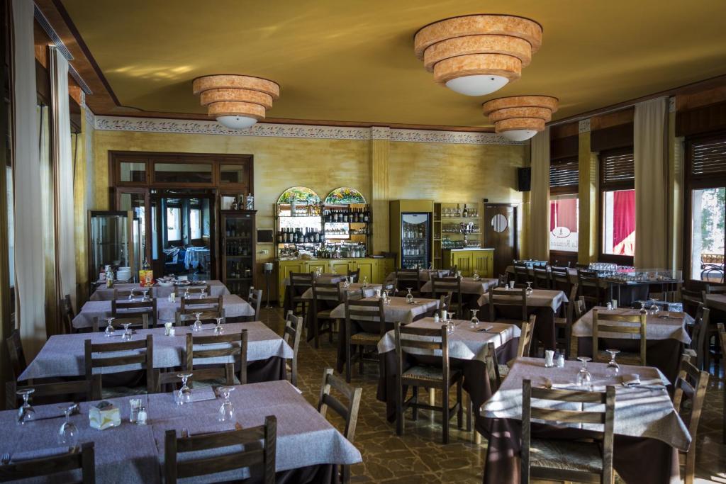 un restaurant avec des tables et des chaises dans une salle dans l'établissement Albergo La Romanella, à Spinone Al Lago