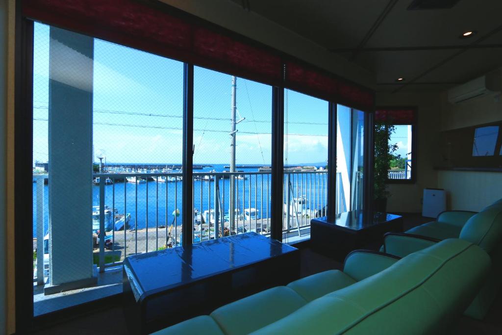 Cette chambre comprend des canapés et offre une vue sur l'eau. dans l'établissement Hotel Seikaisou, à Minamichita