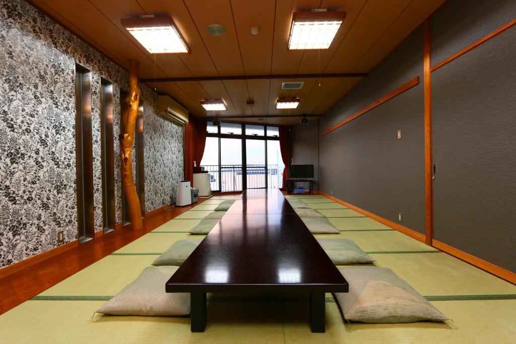 un long couloir avec une table noire dans un bâtiment dans l'établissement Hotel Seikaisou, à Minamichita