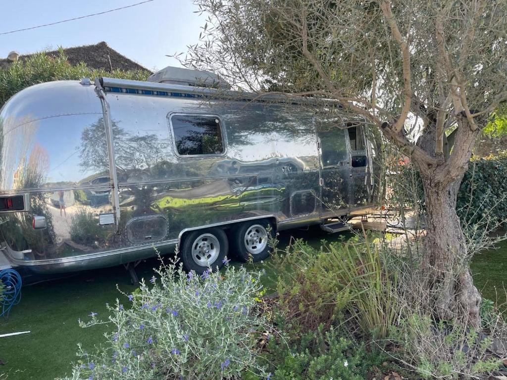 une remorque argentée garée à côté d'un arbre dans l'établissement Pooh’s Belle, à Grimaud