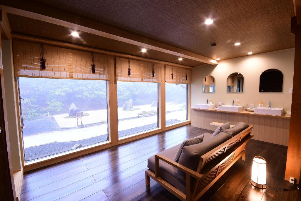 un salon avec un canapé et une grande fenêtre dans l'établissement Koyasan Shukubo Yochiin, à Koyasan