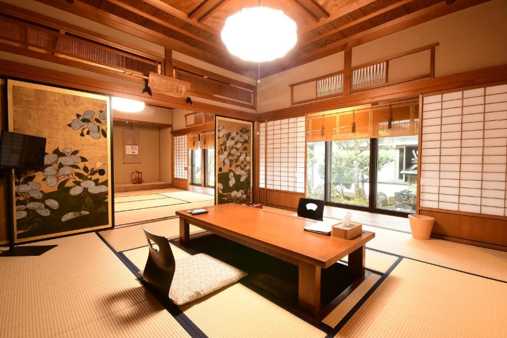 Cette chambre dispose d'une table en bois et de fenêtres. dans l'établissement Koyasan Shukubo Yochiin, à Koyasan