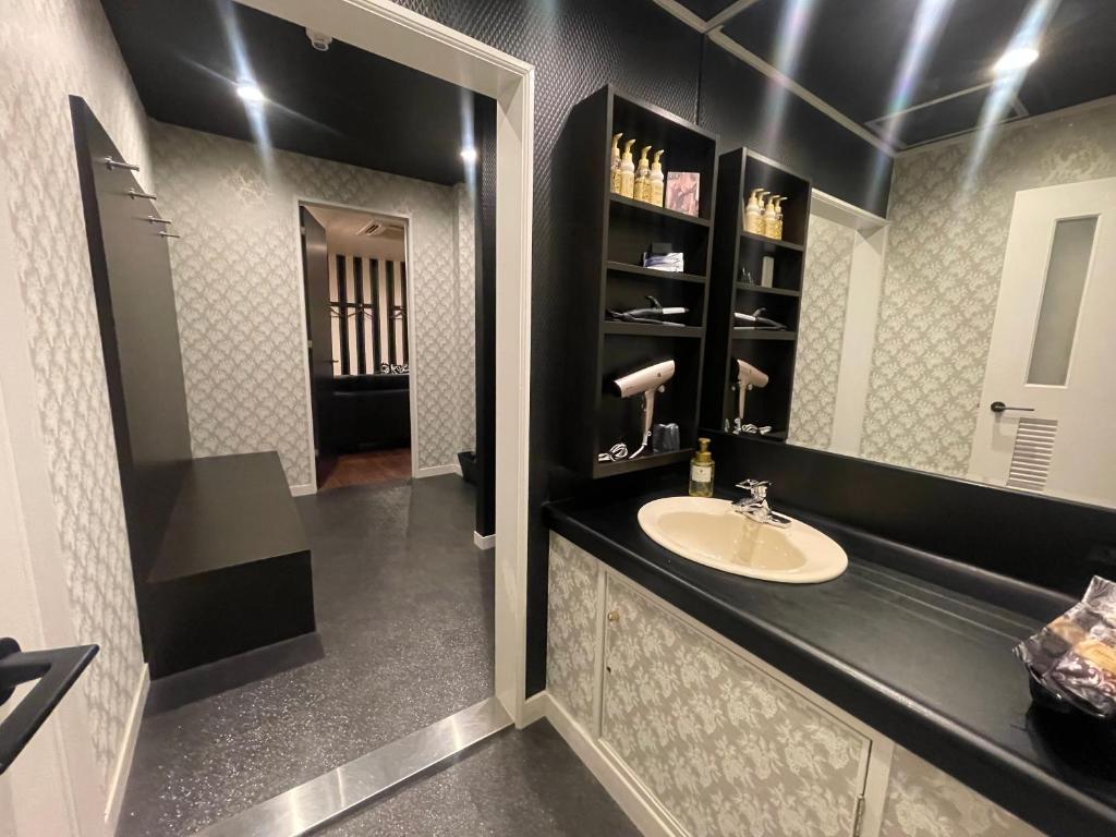 une salle de bain avec un lavabo et un miroir dans l'établissement Xenia Amagasaki, à Amagasaki