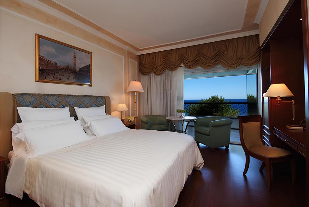 une chambre d'hôtel avec un grand lit et une fenêtre dans l'établissement Grand Hotel Del Mare Resort & Spa, à Bordighera