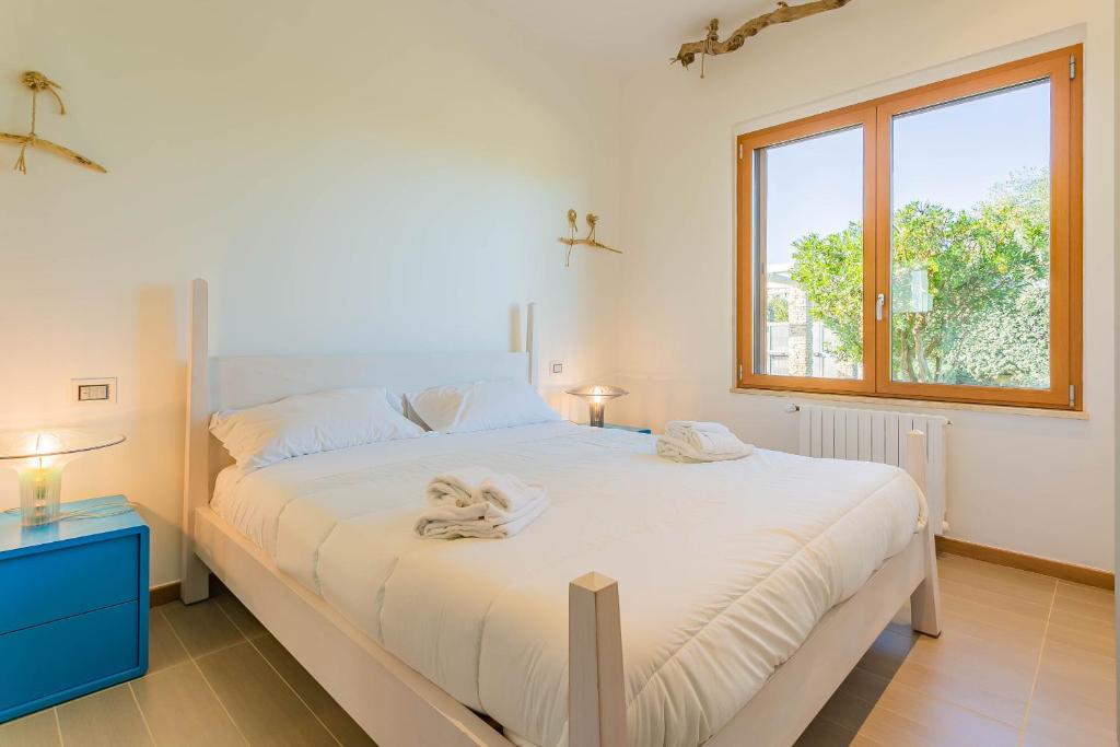 un lit blanc dans une chambre avec une fenêtre dans l'établissement Affittacamere Incanto nel Verde by Wonderful Italy, à Polignano a Mare