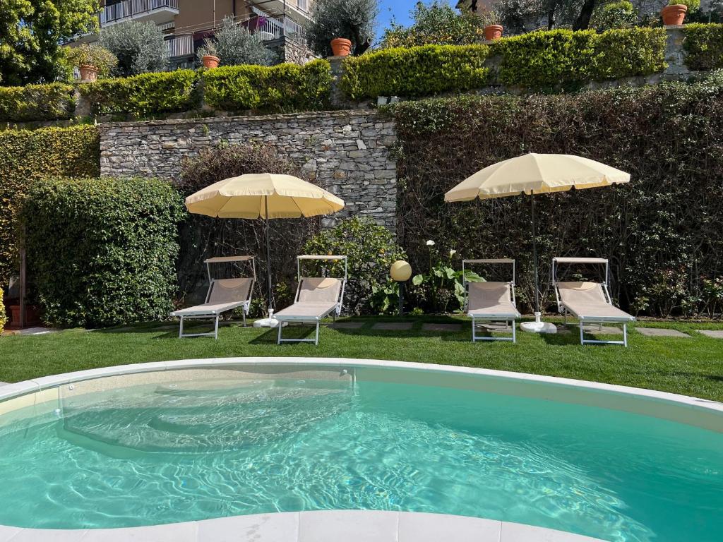 une piscine avec chaises et parasols dans une cour dans l'établissement "Villa degli Ulivi" 19th century Villa with private pool and sea view, à Recco