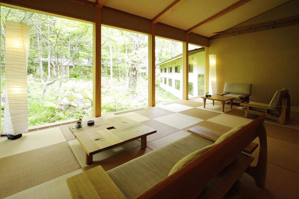 un salon avec un canapé et une grande fenêtre dans l'établissement Mozumo (Adult Only), à Takayama