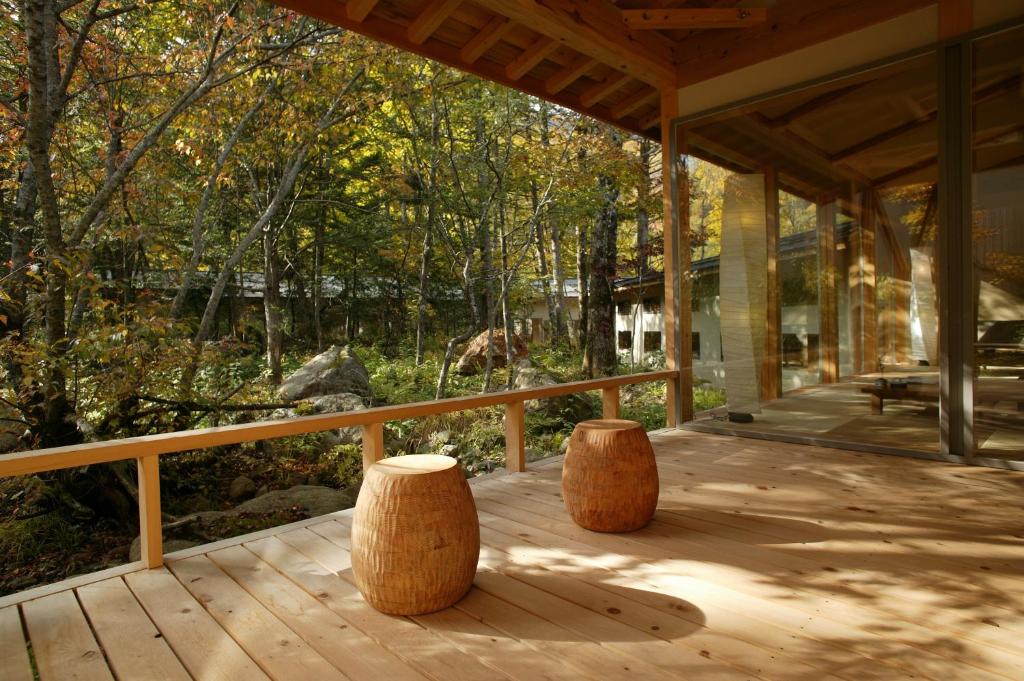 - deux tabourets en bois sur une terrasse couverte avec des arbres dans l'établissement Mozumo (Adult Only), à Takayama