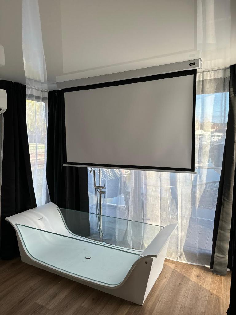 une grande télévision à écran plat dans un salon dans l'établissement L'Escale Royale Saverne - Rhin - Strasbourg, à Saverne