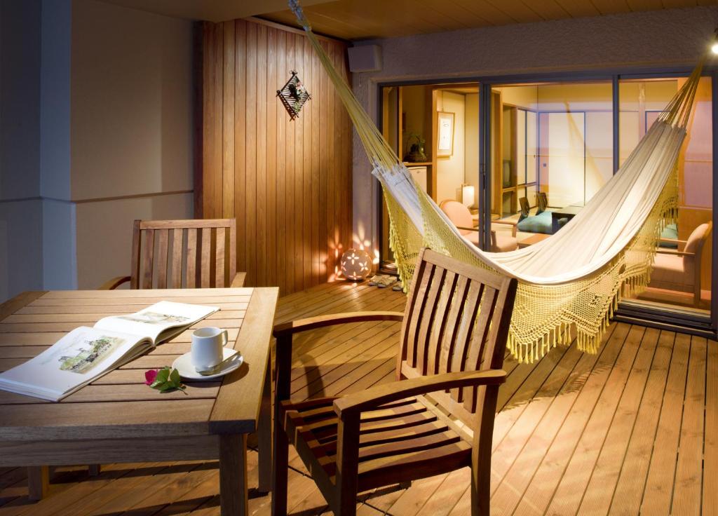 Cette chambre comprend un hamac, une table et des chaises. dans l'établissement Hamanoyu, à Higashiizu