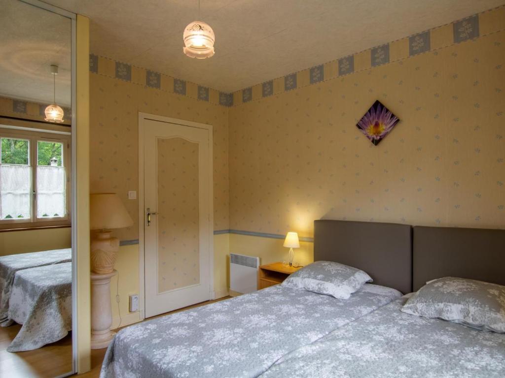 une chambre avec deux lits et un miroir dans l'établissement Maison de charme avec piscine, au cœur de Prats du Périgord, idéale pour 4 pers. et animaux acceptés - FR-1-616-353, à Prats-du-Périgord