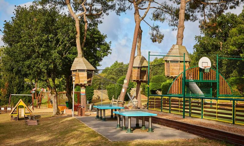 une aire de jeux avec deux tables et une structure de jeux dans l'établissement Mobil home CARNAC, à Carnac