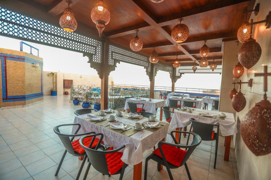 un restaurant avec des tables, des chaises et des lumières blanches dans l'établissement Riad Perle D'Eau, à Essaouira