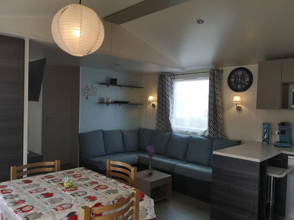 un salon avec un canapé bleu et une table dans l'établissement CHEZ LOLO MH 3CH 2SDB CLIM 8p VUE CHAMPS EMPLACEMENT CALME, à Onzain 20 autres photos