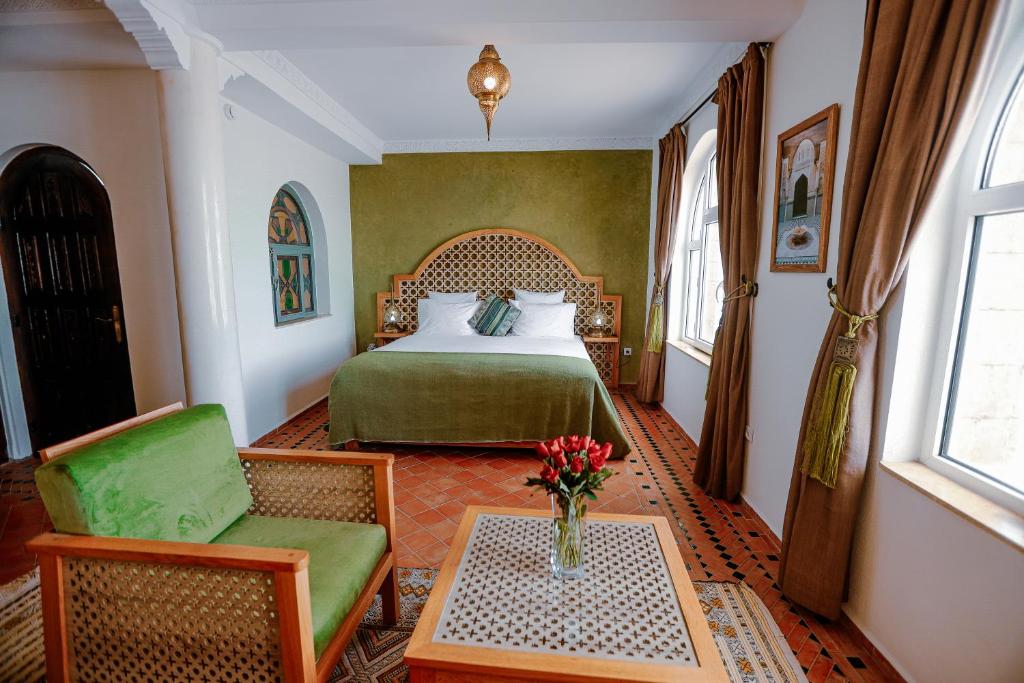une chambre avec un lit, une table et une chaise dans l'établissement Riad Perle D'Eau, à Essaouira
