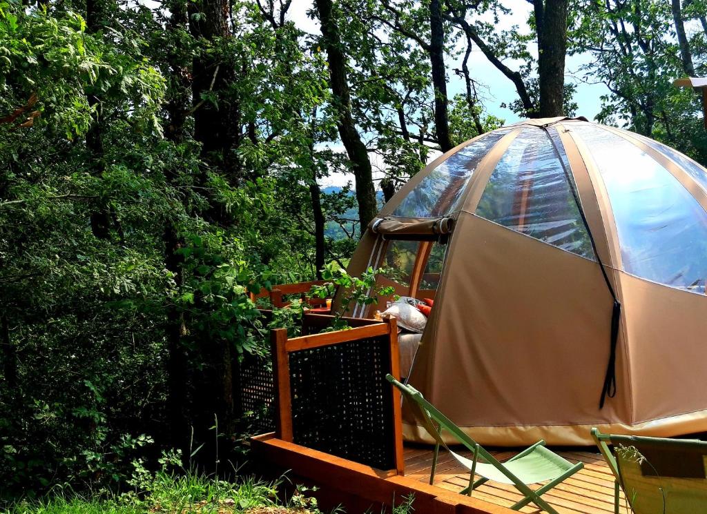 une yourte dans les bois avec une terrasse en bois dans l'établissement Le Mobil'Dôme à Marie, à Cambounès 13 autres photos
