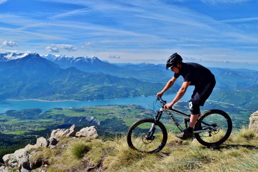 Un homme faisant du vélo au sommet d'une montagne dans l'établissement Duplex dans chalet au coeur de la station, à Réallon