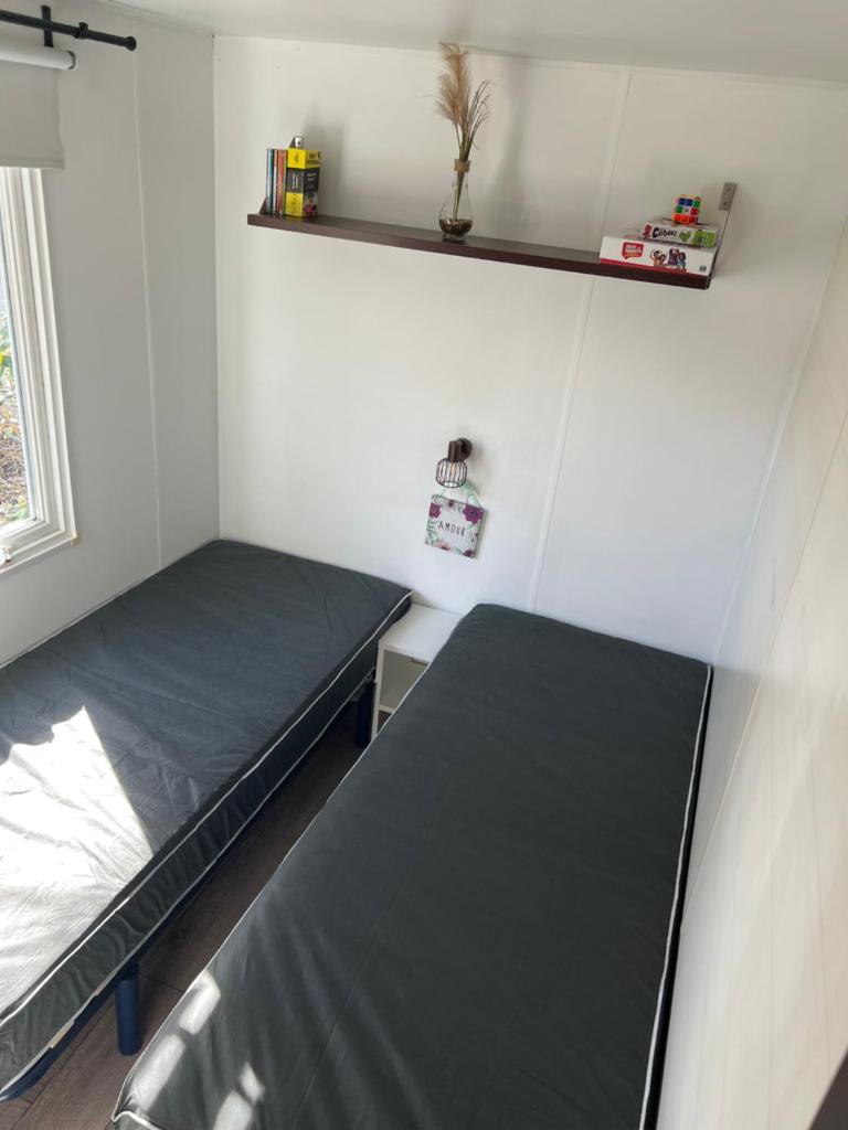 une petite chambre avec deux lits et une fenêtre dans l'établissement chez Sodam by siblu, à Parentis-en-Born