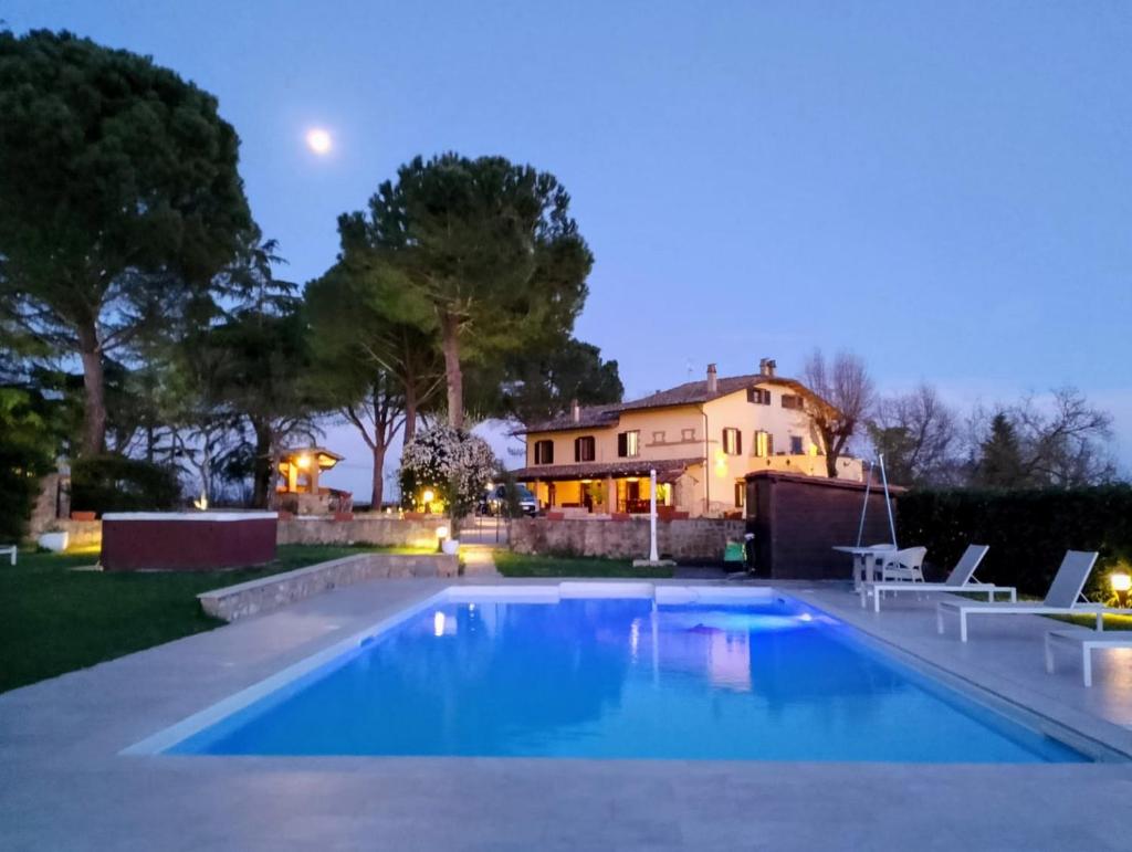 une piscine devant une maison la nuit dans l'établissement Villa Tuscan Prestige 25 ospiti Piscina Jacuzzi, à La Croce