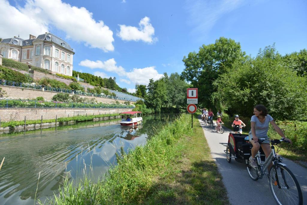 une femme qui emprunte une piste cyclable à côté d'une rivière dans l'établissement SEALOV Hébergements insolites- linge, ménage et vélos inclus, à Eaucourt-sur-Somme 14 autres photos