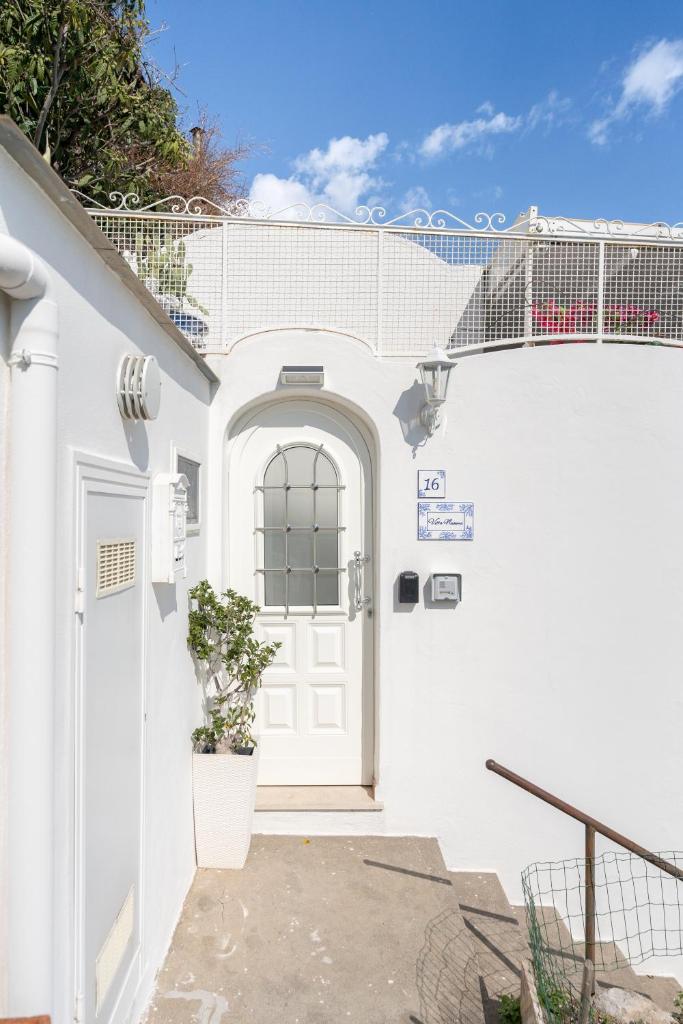 une maison blanche avec une porte blanche et une plante dans l'établissement Villa Navarra, à Praiano 57 autres photos