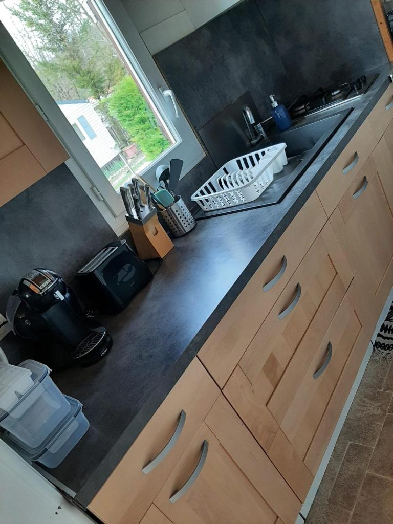 une cuisine avec des armoires en bois, un évier et une fenêtre dans l'établissement Chalet 6 places, à Saint-Thomas-en-Royans
