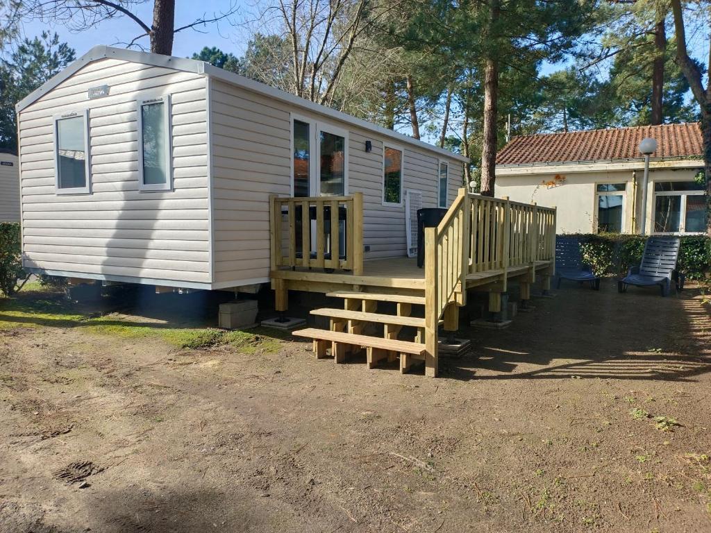 Cette petite maison blanche dispose d'une terrasse couverte et d'escaliers. dans l'établissement Jolie Mobil home 2 chambres (198), à Saint-Jean-de-Monts